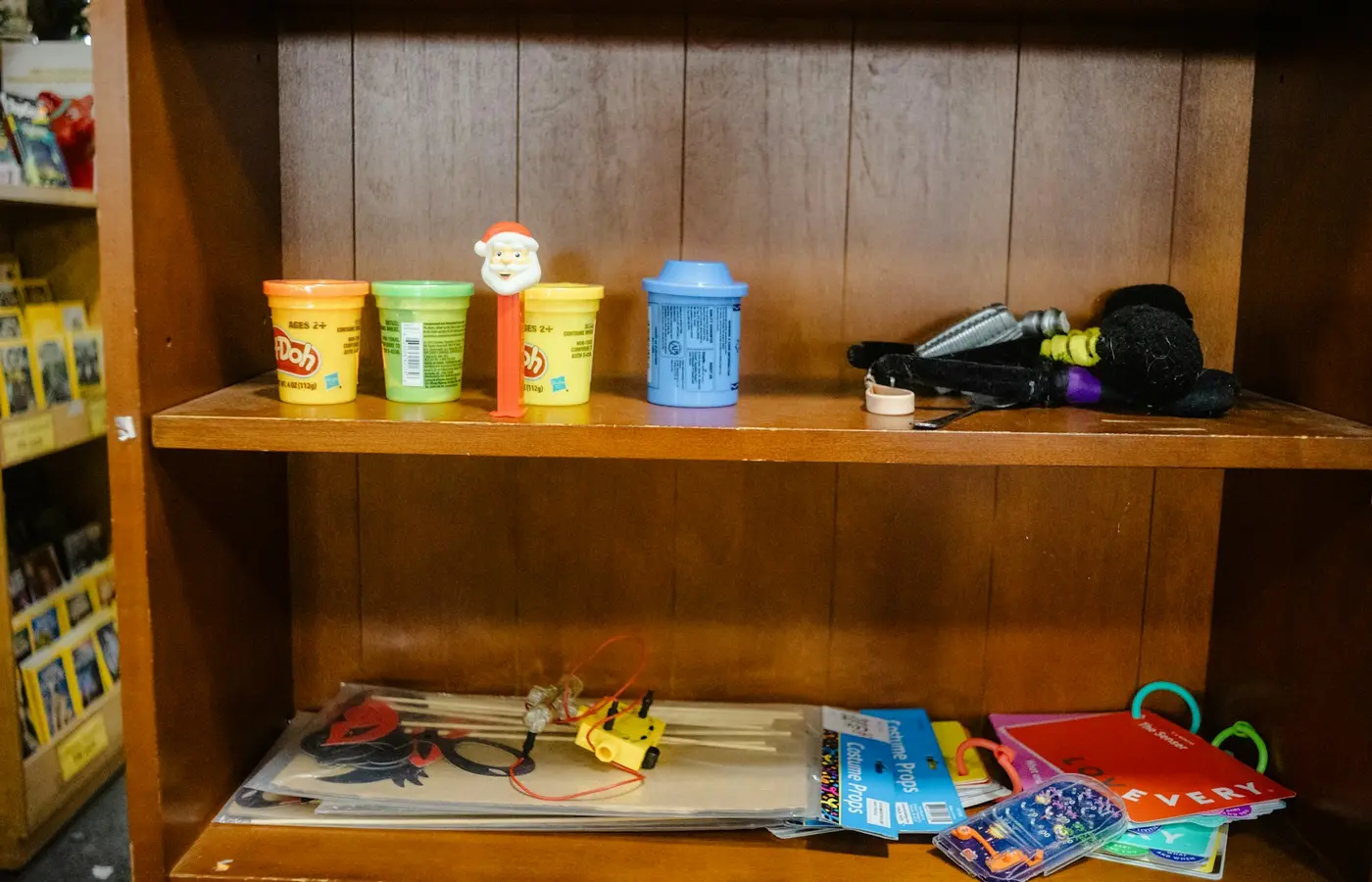 Toys and craft supplies on wooden shelves