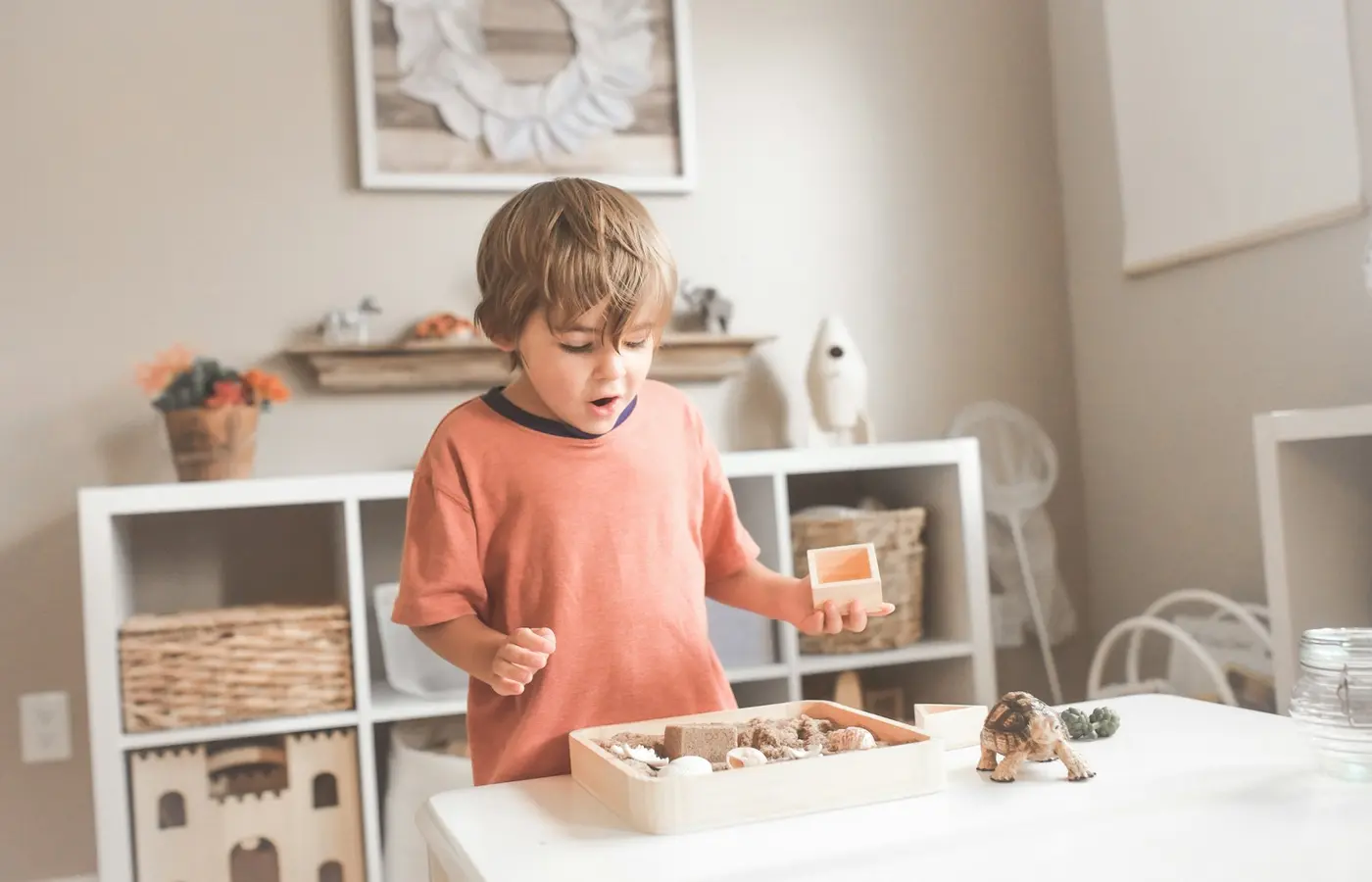 Child revisiting stored wooden toys