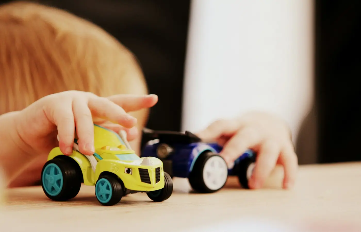A child lining up wooden cars