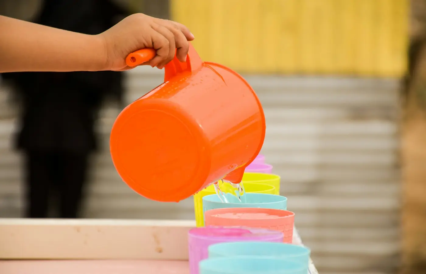 Toddler pouring water with cups